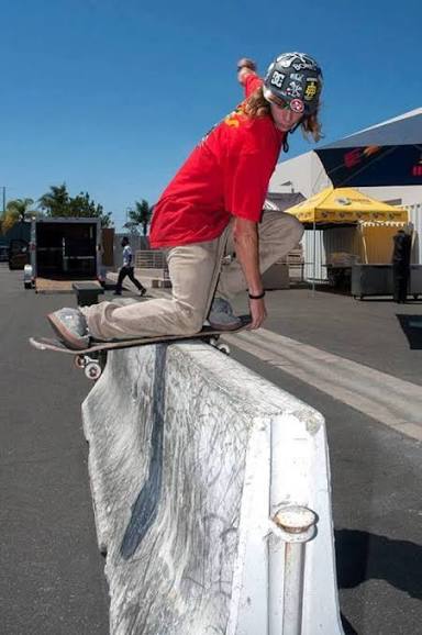 Street skater not wearing a helmet during trick on barrier